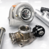 EMS EcoBoost big turbo kit with stainless piping, turbocharger, intake filter, and full installation components displayed on a white reflective surface